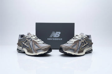 Pair of New Balance running shoes on a concrete surface with a box in the background.