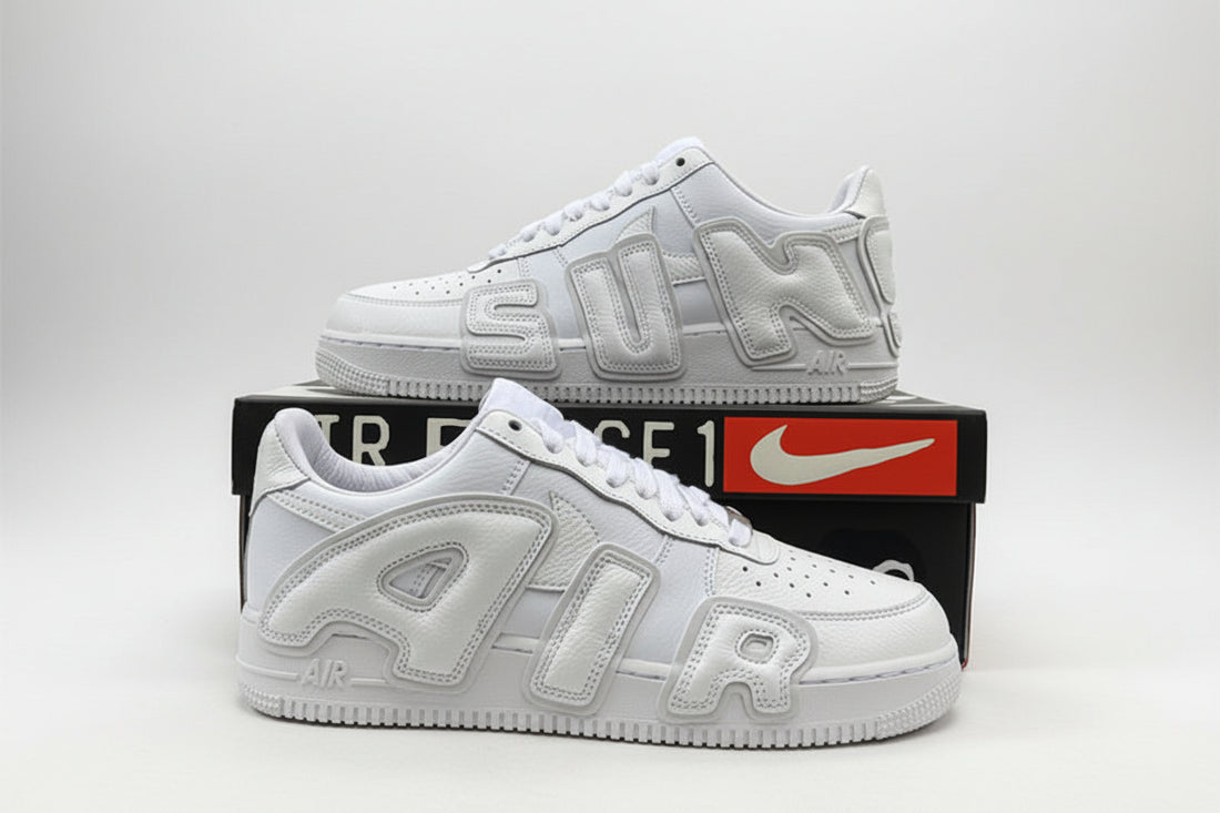 White sneakers with 'AIR' branding on a black box with Nike logo, outdoor setting.