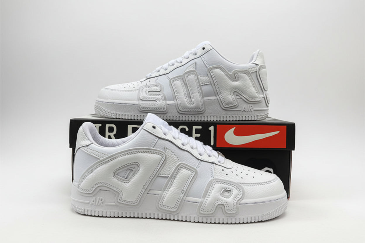 White sneakers with 'AIR' branding on a black box with Nike logo, outdoor setting.