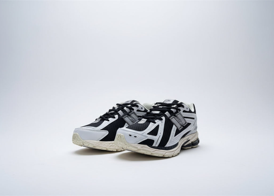 Black and white sneakers with New Balance logo on a blurred outdoor background