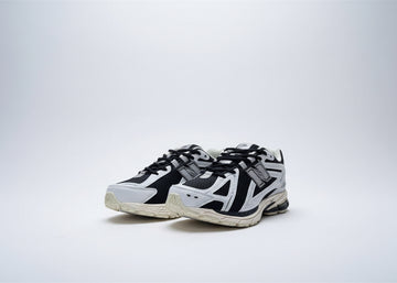 Black and white sneakers with New Balance logo on a blurred outdoor background